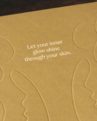 Imagen de acercamiento a la frase decorativa del empaque del set "let your inner glow shine through your skin"
