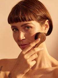 Imagen de mujer mostrando cómo usar el cépillo facial. 