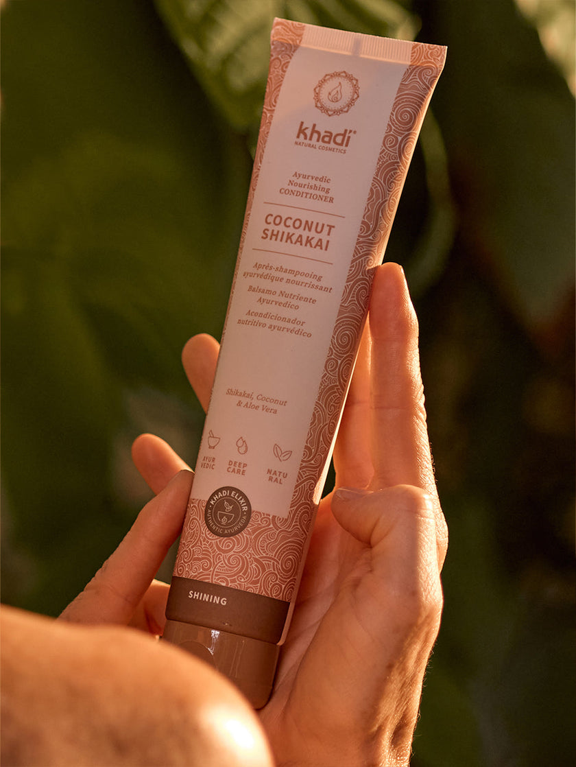 Modelo mostrando el acondicionador Coconut Shikakai
