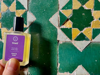Imagen ilustrativa del frasco de aceite para uñas sobre mosaicos de color