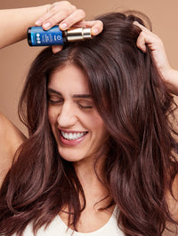 Modelo aplicando aceite capilar Neem en su cabello