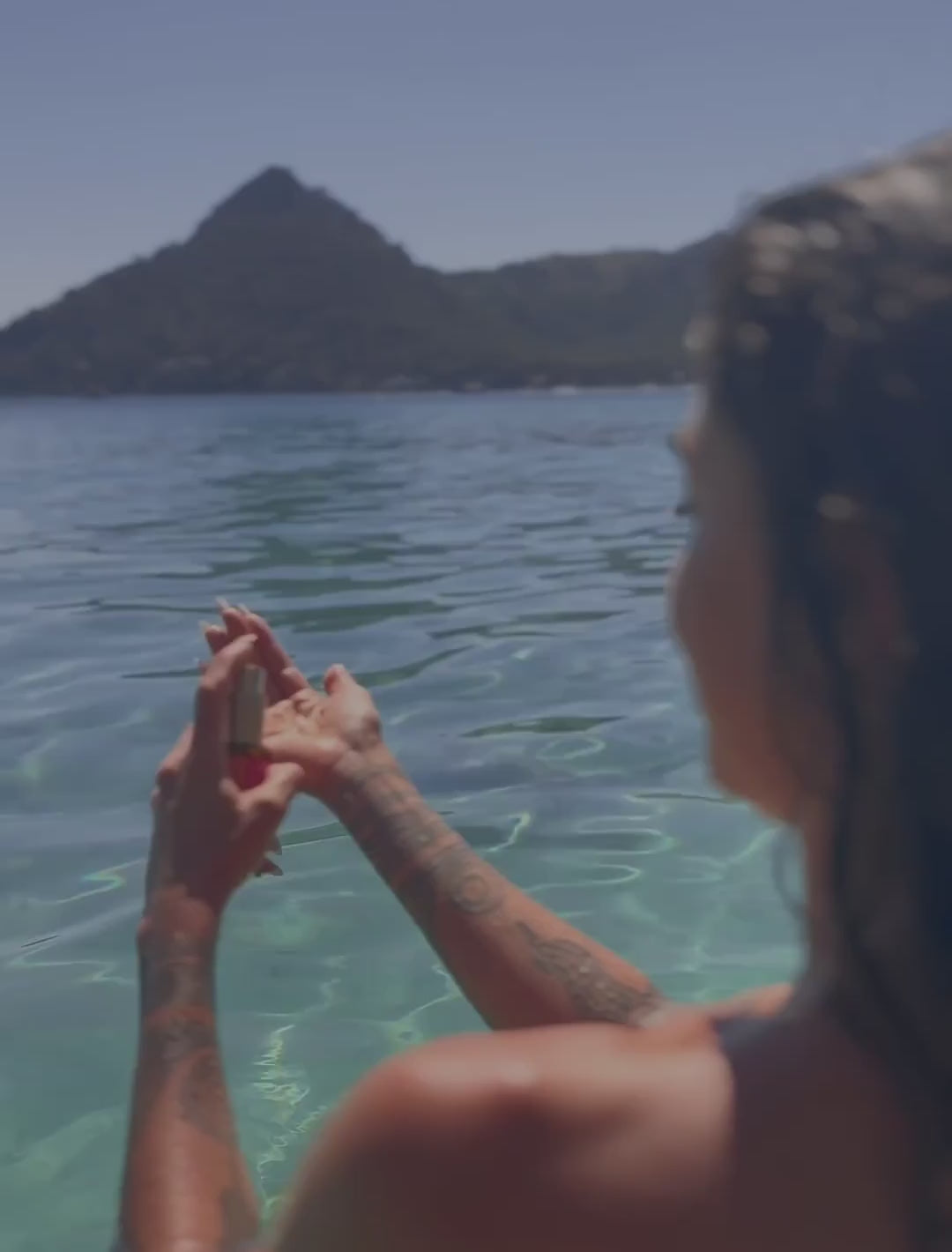 Video de modelo en la playa aplicando el aceite Color Care en el cabello
